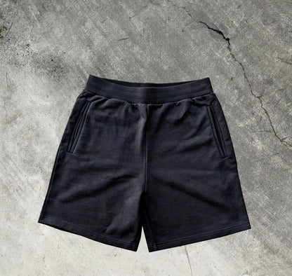 Deep pocketed dark black shorts with elastic waistband and drawcord made from french terry cotton